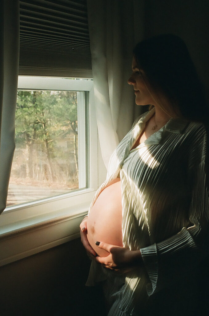 film photo of wife posing holding her pregnant belly