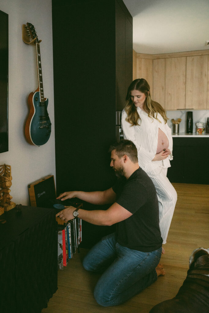 wife looking at husband while he sets up the record player