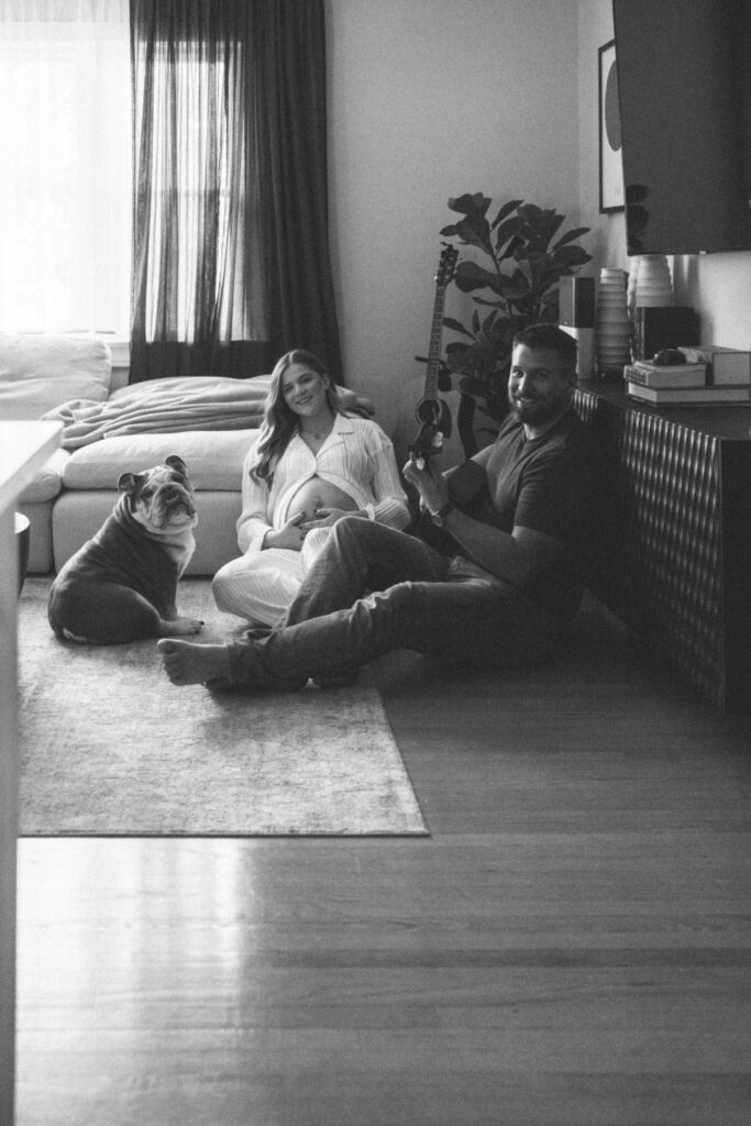 husband, wife, and dog relaxing in their living room, smiling