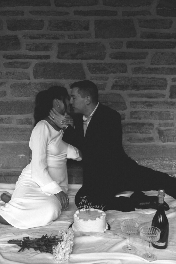 husband and wife kissing in front of their anniversary cake