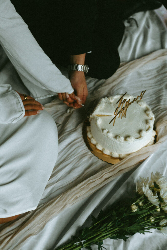 husband and wife cutting their anniversary cake with an inserted sign saying their last name