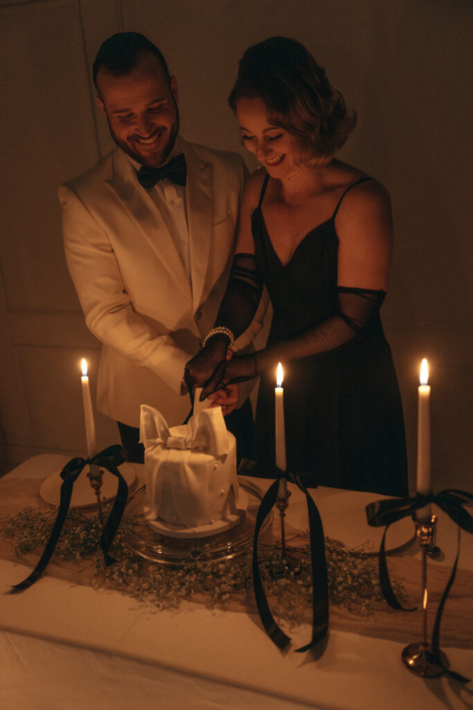 husband and wife cutting a cake while smiling