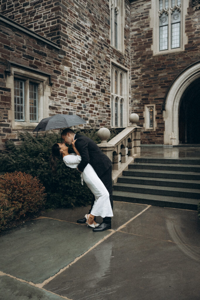 husband dipping his wife outside with an umbrella over their heads