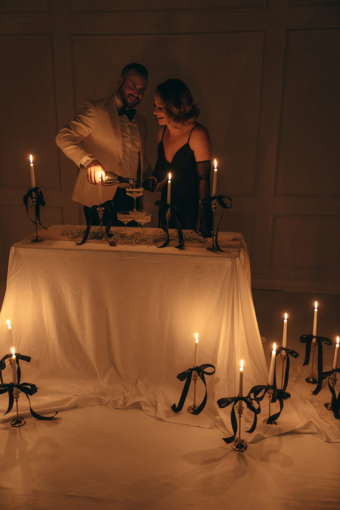 husband and wife pouring champagne into a mini champagne tower