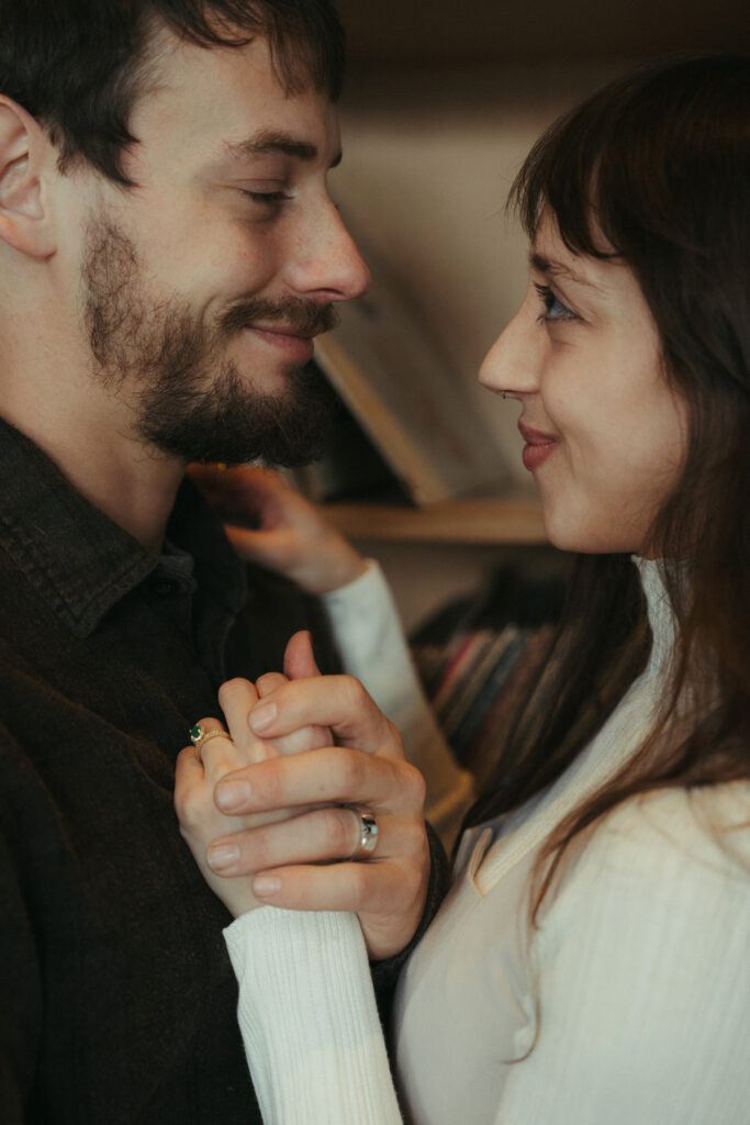 couple embraced and holding hands while smiling at each other