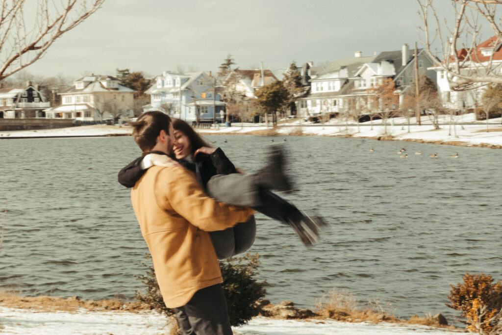 her fiance holding her in his arms while walking and spinning her around