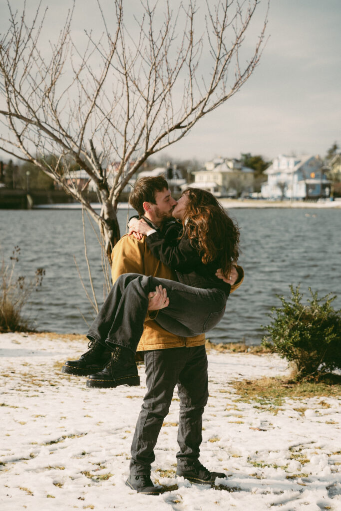 couple kissing while the man is holding his fiance in his arms