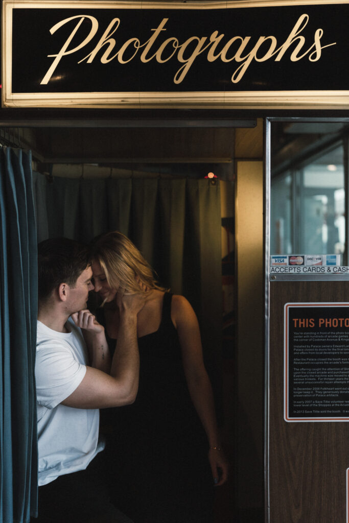 couple in photobooth while the man goes in for a kiss