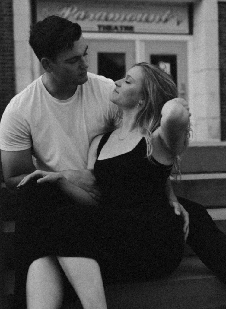 couple sitting on steps in front of theatre