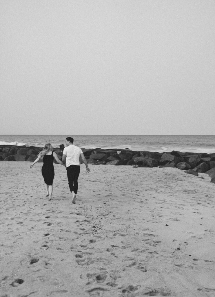 couple running and holding hands on the beach