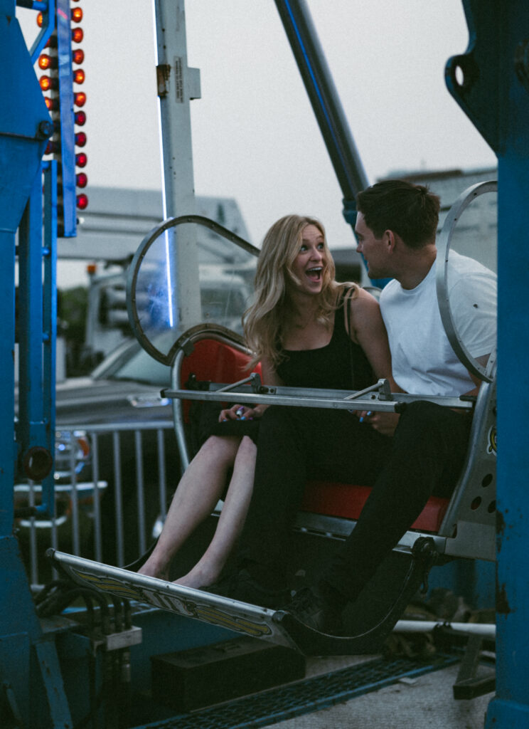 couple on Ferris wheel while the woman has a surprised look on her face