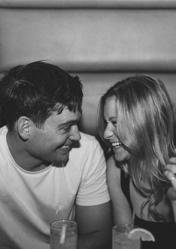 couple laughing at each other at the bar