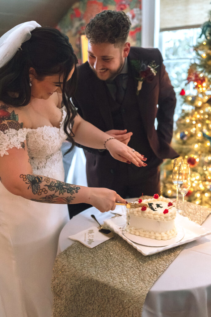 bride and groom laughing and cutting their wedding cake