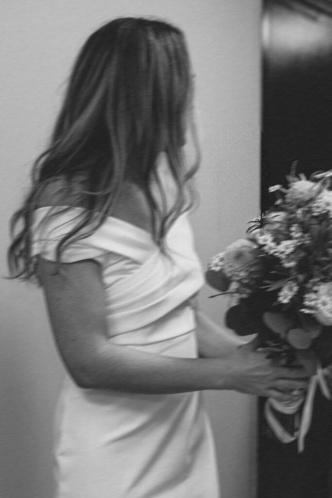 bride looking away from camera while holding her boquet